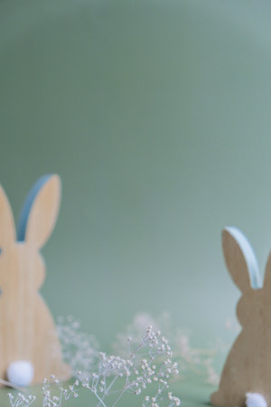 Defocused background Wooden minimalism low-key bunny decor in pastel green background. Sustainable holiday minimalistic still life composition. Copy space template for invitation greeting cardの写真素材