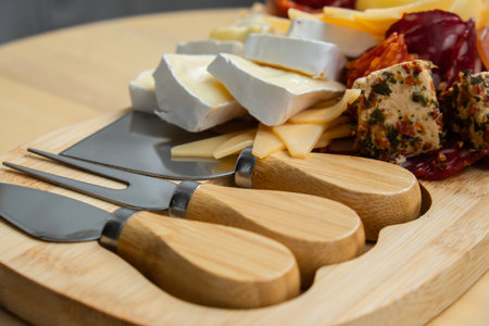 Wooden charcuterie cheese board holiday present idea. Snack starter plate for dinner with wine. Italian appetizers or antipasto set with gourmet food. Buffet partyの写真素材