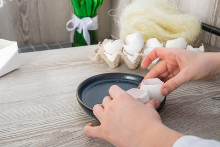 Tutorial How to make Easter table decoration with egg shells step by step instruction. Easter home decoration on wooden branch. Seasonal sustainable recycledの写真素材