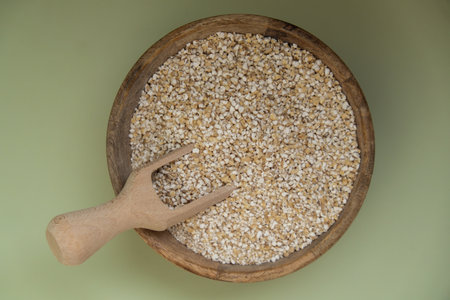 Fine ground barley in green background copy space Whole spelt grain species. High protein fiber-rich vegan plant based food ingredient. Gluten free superfood healthy nutritional dietary alternativeの写真素材