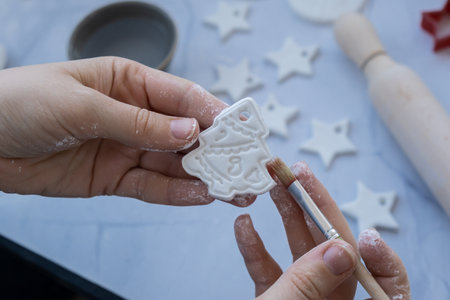 Master class of painting Creator is using white air dry clay for making decor to Christmas tree holiday. Creating hobby recreation activity that involves fingers. DIY craftingの写真素材