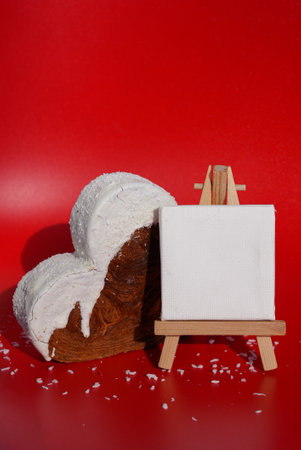 White paper note mockup template greeting holiday card Heart shaped coconut flavor croissant on red background with copy space. Puff pastry new trendy sweet dessert bakery.の写真素材
