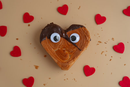 Delightful and vibrant heartshaped pastry croissant treat, beautifully topped with colorful frosting galore. Food experimentation dessert creative baking trendの写真素材