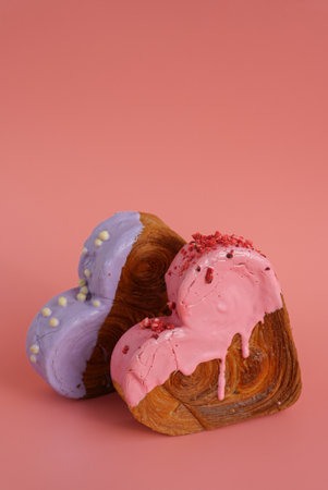 Heart shaped two couple croissants on pink background with copy space. Puff pastry new trendy sweet dessert bakery. Creamy doughの写真素材