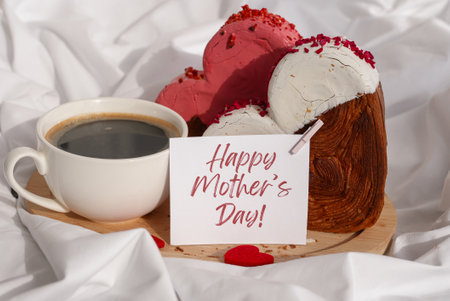 Happy mothers day wishes saying caption on greeting card Coffee breakfast in rumpled bedding bed with heartshaped pastry croissant treat. Food experimentation viral dessert baking trendの写真素材