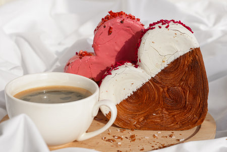 Morning breakfast coffee wooden tray bed rumpled bedding Valentines Day Birthday celebration Delicious fresh variety croissants topped with colorful flavor Ganache. Creation unique heart shape bakery. Puff pastry holiday love gift present ideaの写真素材