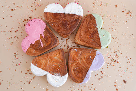 Flat lay greeting card Valentines Day Delicious fresh variety croissants topped with colorful flavor Ganache. Creation unique heart shape bakery. Puff pastry holiday love gift present ideaの写真素材
