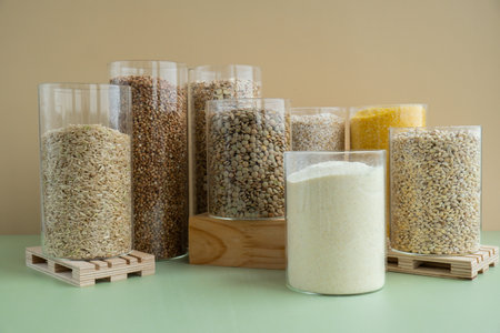 Refillable glass jar with raw grain porridge. Copy space Refill product format eco-friendly living. Filling reusable container Whole spelt grain species. High protein fiber-rich vegan plant based food ingredient. Gluten free superfood healthy nutritional dietaryの写真素材