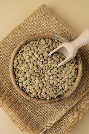 Green lentil in neutral beige background copy space.Whole spelt grain species. High protein fiber-rich vegan plant based food ingredient. Gluten free superfood healthy nutritional dietary alternativeの写真素材