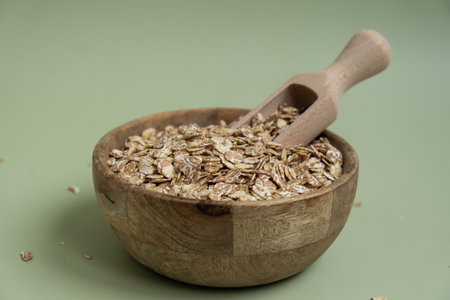 Raw oatmeal porridge in green background copy space. Whole spelt grain species. High protein fiber-rich vegan plant based food ingredient. Gluten free superfood healthy nutritional dietary alternativeの写真素材