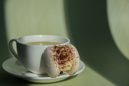Nutrient-rich matcha drink with macaron dessert and trendy deep shadows on soft colored background. Morning beautiful breakfast present gift idea. Vibrant creative colors. Natural energy giversの写真素材