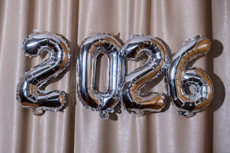 Happy new year 2026 metallic balloons on atlas textile background. Greeting card silver foil balloons numbers Christmas holiday concept. Celebration party congratulationの写真素材