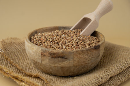 Raw buckwheat porridge in neutral beige background copy space. Whole spelt grain species. High protein fiber-rich vegan plant based food ingredient. Gluten free superfood healthy nutritional dietary alternativeの写真素材