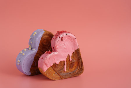 Valentine's Day Birthday holiday present gift idea Delightful and vibrant heartshaped pastry croissant treat, beautifully topped with colorful frosting galore. Copy space. Food experimentation viral dessert creative baking trendの写真素材