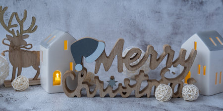 Merry Christmas wooden message with Christmas winter holiday decoration clay houses with light....