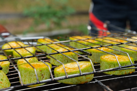 Chopped zucchini and khachapuri roasting on fire seasoned with aroma herbs and spices. Delicious fresh vegetables vegetarian grilling on barbecue smoker grid. Diet vegan bbq. Outdoor recreationの写真素材