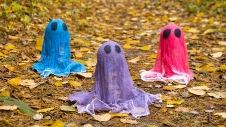 Halloween holiday concept. Handmade colorful ghosts made from bandages and glue in autumn forest background. Childrens art project. DIYの写真素材