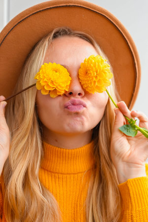 Woman close her eyes with yellow dahlia Autumn garden colorful flowers. Beautiful autumnal bouquet dahlia chrysanthemum. Red pink orange fall color fall floral background. Flower shop and florist design conceptの写真素材