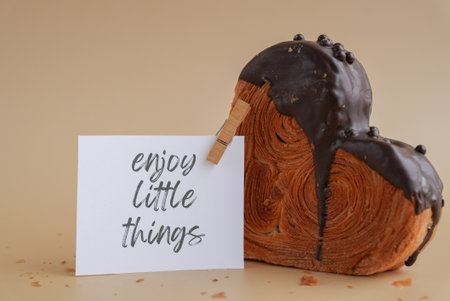 ENJOY LITTLE THINGS words on paper note Delicious fresh croissant topped with Dark chocolate flavor...