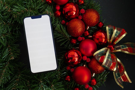 Mobile phone mock up template white screen on handmade Christmas wreath. Festive mood new year celebration. Postcard decoration decorの写真素材