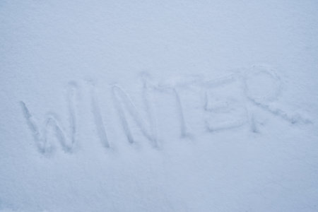 Word WINTER written in the frozen snow in winter season. Concept of cold snowy weather forecast. Freezing climate change natural disaster challengingの写真素材