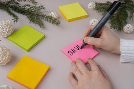 Female hands writing handwritten new year resolutions aims goals on sticky notes. Preparation for...