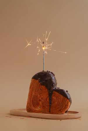 Holiday birthday anniversary shiny candle sparkler on cake Delightful and vibrant heartshaped pastry...
