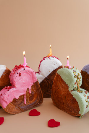 Holiday birthday anniversary shiny candle sparkler on cake Delightful and vibrant heartshaped pastry croissant treat, beautifully topped with colorful frosting galore. Food experimentation dessert creative baking trendの写真素材