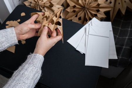 Process of preparing for Christmas star and New Year eve. 3D craft bag snowflakes DIY. Responsible ecological zero waste handmade decoration. Children hobby activityの写真素材