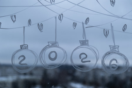2026 Painted window with white marker. New Year number decoration on big clear window. Snowy winter outside. Zero waste decor conscientious celebrationの写真素材