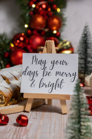 Greeting card with message MAY YOUR DAYS BE MERRY AND BRIGHT congratulations. Christmas Stollen in...