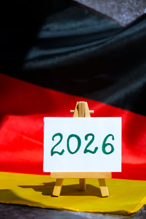 Paper note with text 2026 on National symbol of Germany. German wave silky flag background....