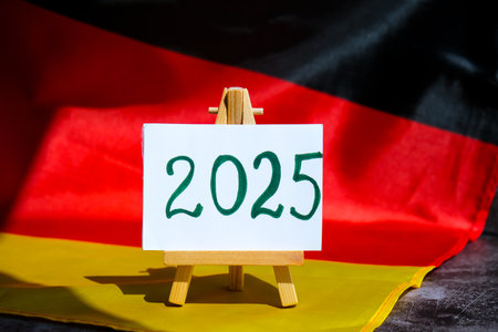 Paper note with text 2025 on National symbol of Germany. German wave silky flag background....