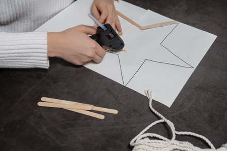 Ice cream sticks Christmas star Sustainable preparation Diy process making handmade decoration. Step by step activity for children. Inclusive and responsible stress relief holiday hobbyの写真素材