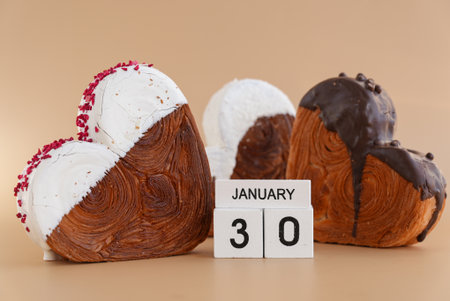 30 January National Croissant Day holiday calendar date celebration greeting card Heart shaped dark chocolate flavor croissant on beige background with copy space. Puff pastry new trendy sweet dessert bakery. Creamy doughの写真素材
