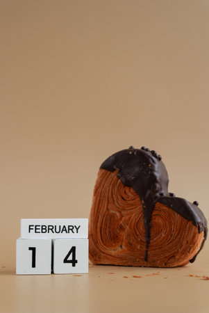 Valentines Day 14 February wooden calendar cubes wishes greeting holiday card Heartshaped pastry croissant treat topped with colorful frosting galore. Food experimentation viral dessert baking trendの写真素材