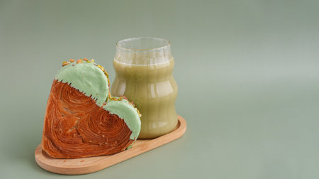 Drink beverage coffee cappuccino latte Delicious fresh croissant topped with Matcha Green Tea flavor Ganache. Creation unique heart shape bakery. Puff pastry holiday love gift present idea Valentines dayの写真素材