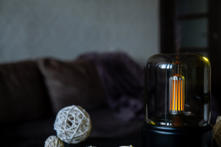 Close up of home perfume scent air humidifier with light. Aromatherapy holistic health practices concept. Stress relief activities preparing for meditation. Simple pleasures healingの写真素材