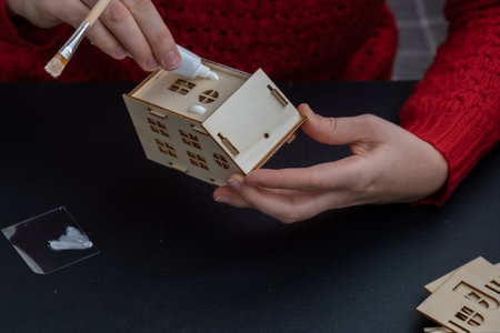Process of preparing for Christmas and New Year eve. 3D craft wooden houses DIY. Responsible...