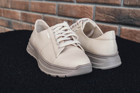Fresh beige leather sneakers without brand marks displayed. For design templates online shops and sustainability-themed marketing. Clean blank sneakersの写真素材