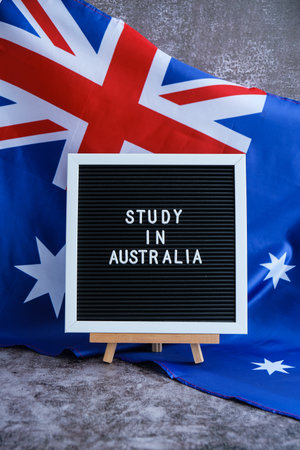 Message STUDY IN AUSTRALIA on background of Australian flag made from silk. Australia national flag with concept of tourism and traveling students opportunities scholarship programsの写真素材