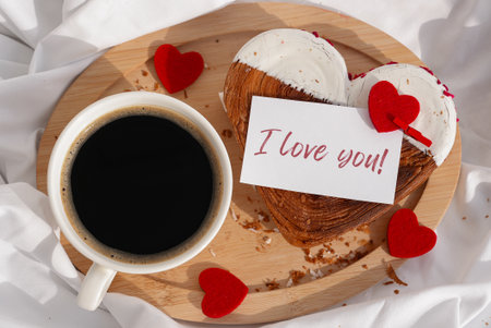 Flat lay top view I LOVE YOU saying on greeting card Morning breakfast in bed in wooden tray Present gift idea Valentines Day Holiday celebration Heart shaped croissants. Puff pastry new trendy sweet dessert bakery. Creamy doughの写真素材