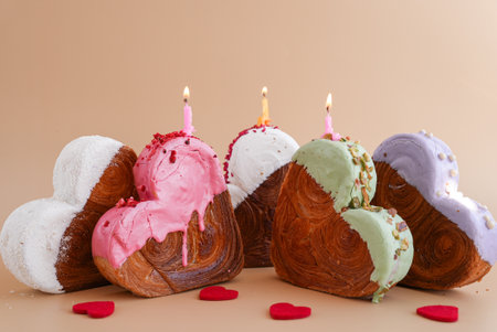 Holiday celebration with candles Heart shaped different variety flavor croissants on beige...