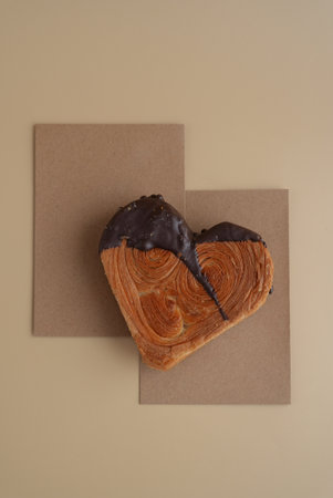 Empty paper note template sample mock up blank for wishes greeting holiday card Heartshaped pastry croissant treat topped with colorful frosting galore. Food experimentation viral dessert baking trendの写真素材