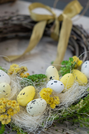 Handmade Easter wreath festive yellow egg decorations. Traditional holiday preparation craft master...
