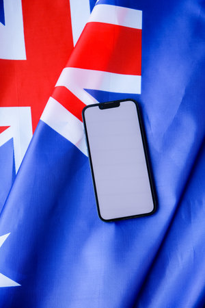 Smartphone with empty white screen on background of Australian flag. Mock up template copy space for custom copy designs. Place your logo or text on the white screen phoneの写真素材