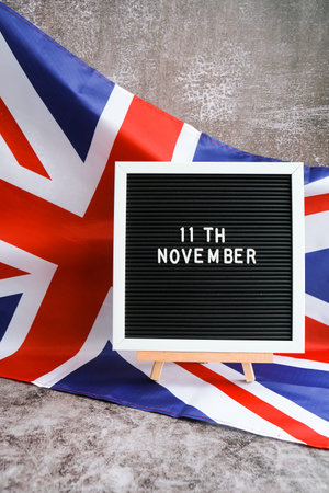 Minimal patriotic scene with signboard and waving flag date 11th November UNITED KINGDOM with...