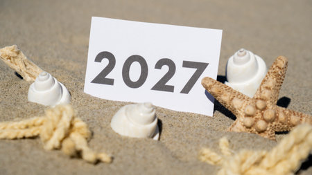 2027 text start new year symbol on paper on background of starfish summer vacation decor. Sandy...