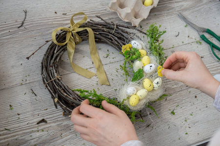 Handmade Easter wreath festive yellow egg decorations. Traditional holiday preparation craft master...