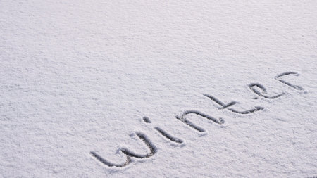 Written WINTER on snow background message ice outdoor on ground in winter. Writing text sign and drawing on field in frozen background. Weather is changing cold season has arrived. Mockup Copy space Creative art and textureの写真素材